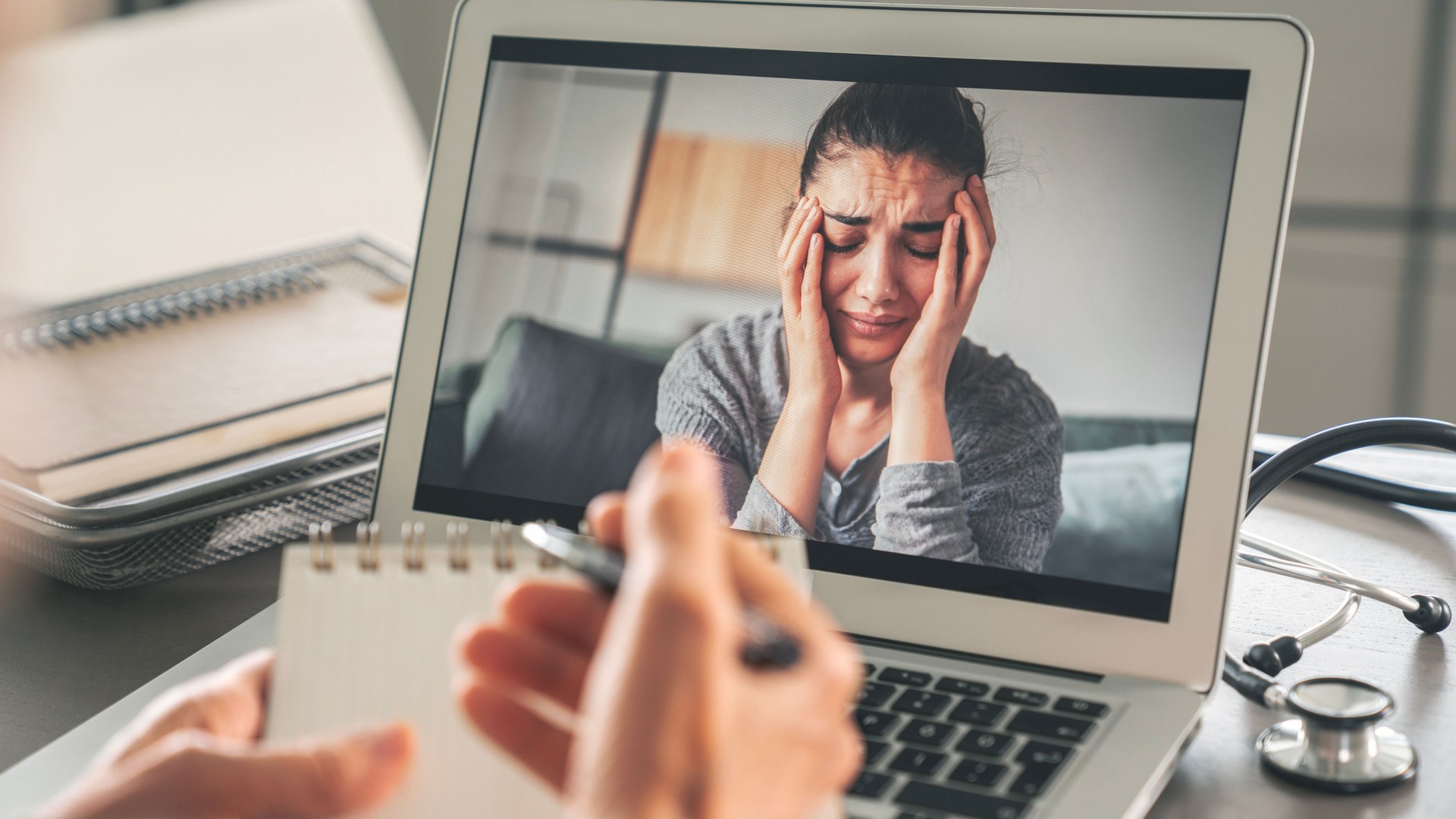 Female psychologist calms down emotional crying woman patient by video call on computer